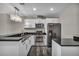 Modern kitchen with stainless steel appliances, dark counters, white cabinetry and designer chandelier at 4525 Dean Martin Dr # 2903, Las Vegas, NV 89103