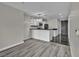 Modern living area flowing into kitchen, featuring gray hardwood floors and stylish pendant lighting above the breakfast bar at 4525 Dean Martin Dr # 2903, Las Vegas, NV 89103