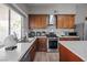 Modern kitchen features stainless steel appliances, white countertops, wooden cabinets, and a view to the yard at 5375 Chestnut St, Las Vegas, NV 89119