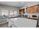 Bright kitchen with stainless steel appliances, white countertops, wooden cabinets, and an island with barstool seating at 5375 Chestnut St, Las Vegas, NV 89119