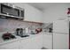 Well-lit kitchen features white cabinets, modern appliances, and stylish marble backsplash at 5375 Chestnut St, Las Vegas, NV 89119