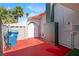 Red patio offers a unique outdoor space, accompanied by palm trees and a blue trash can at 5375 Chestnut St, Las Vegas, NV 89119