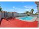 Backyard pool with trampoline, red painted concrete, and block wall at 5375 Chestnut St, Las Vegas, NV 89119