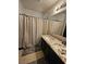 Bathroom features a sink vanity with granite counters and shower/tub with patterned curtain at 5419 Brass Hills Ct, Las Vegas, NV 89122