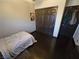 Bedroom with dark hardwood floors, neutral walls, closet, and a decorative poster on the wall at 5419 Brass Hills Ct, Las Vegas, NV 89122