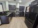 Modern kitchen with dark cabinets, stainless steel appliances, granite countertops, and stylish tile flooring at 5419 Brass Hills Ct, Las Vegas, NV 89122
