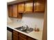 Functional kitchen with laminate countertops, wooden cabinets, and double sink at 5841 Medallion Dr # 102, Las Vegas, NV 89122