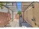 Enclosed backyard patio area with custom pavers, iron pergola and mature trees at 589 Brinkburn Point Ave, Las Vegas, NV 89178