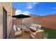 Beautifully furnished patio with outdoor furniture, umbrella, and artificial turf at 6056 Atlantis Dream Ave, Las Vegas, NV 89139