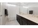 Bright bathroom featuring a cream-colored countertop, dark cabinets, and a large framed mirror at 6056 Atlantis Dream Ave, Las Vegas, NV 89139