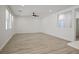Bright living room with plank flooring, ceiling fan, and an opening to the kitchen area at 6133 Roseboro Ct, North Las Vegas, NV 89081