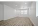 Bright living room showcasing new plank flooring, fresh paint, and many windows for natural light at 6133 Roseboro Ct, North Las Vegas, NV 89081