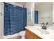 Bathroom featuring a vanity, toilet, and tub/shower combination with blue, wave-patterned curtain at 6351 Abacus Farms Ct, Las Vegas, NV 89131