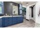 Bathroom featuring a modern vanity with blue cabinets, a well-lit mirror, and a doorway to a walk-in closet at 6351 Abacus Farms Ct, Las Vegas, NV 89131