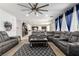 Open-concept living area with comfortable seating, ceiling fan, and view into kitchen at 6351 Abacus Farms Ct, Las Vegas, NV 89131