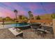 Backyard oasis with a swimming pool featuring a rock waterfall, spa, built-in grill, and lush landscaping at 6351 Abacus Farms Ct, Las Vegas, NV 89131