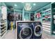 Organized walk-in closet with custom shelving, hanging racks, and a washer/dryer setup for convenience at 6351 Abacus Farms Ct, Las Vegas, NV 89131