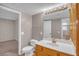 Bathroom with white vanity, wood cabinetry, and a framed mirror, plus access to adjacent room at 701 Capri Dr # 6A, Boulder City, NV 89005