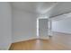 Empty bedroom with light wood-look floors leading to a hallway with an entry door at 7133 Tropical Island Cir, Las Vegas, NV 89129