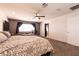 Spacious bedroom with plush carpet, ceiling fan, and window for natural light and access to a bathroom at 815 Adagio St, Henderson, NV 89052