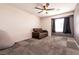 Carpeted bedroom featuring neutral walls, a ceiling fan, and a comfortable couch for relaxing at 815 Adagio St, Henderson, NV 89052