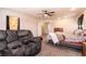 Cozy bedroom featuring a comfortable recliner, ceiling fan, carpet, and access to the ensuite bathroom and closet at 815 Adagio St, Henderson, NV 89052