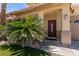 Inviting front entrance featuring a decorative door, lush landscaping, and a security system at 815 Adagio St, Henderson, NV 89052
