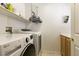 Bright laundry room featuring front loading washer and dryer and cabinet-mounted sink at 815 Adagio St, Henderson, NV 89052