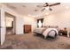 Large carpeted main bedroom features a ceiling fan and view into an adjacent living space at 815 Adagio St, Henderson, NV 89052