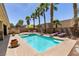 Inviting backyard pool and spa area lined with palm trees, barbeque, and lounge chairs at 815 Adagio St, Henderson, NV 89052