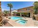 Stunning backyard oasis with refreshing pool, spa, covered patio, and lush palm trees at 815 Adagio St, Henderson, NV 89052
