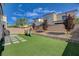 Backyard with artificial turf, play equipment, retaining wall, and privacy wall at 8531 W Oquendo Rd, Las Vegas, NV 89113