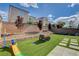 Backyard with artificial turf, stone features, equipment, and partial privacy wall at 8531 W Oquendo Rd, Las Vegas, NV 89113