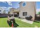 Backyard featuring synthetic grass, stone patio tiles, outdoor grill, and play equipment at 8531 W Oquendo Rd, Las Vegas, NV 89113