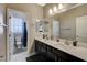 Well-lit bathroom featuring a double vanity with large mirrors and adjoining water closet at 8531 W Oquendo Rd, Las Vegas, NV 89113