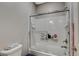 Bright bathroom featuring a tiled shower and tub, complemented by a glass door at 8531 W Oquendo Rd, Las Vegas, NV 89113