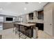 Modern kitchen island with bar seating, sleek countertops, stainless steel appliances, and an open view of the living area at 8531 W Oquendo Rd, Las Vegas, NV 89113