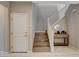 Entry way with wooden stairs, white railing, and tiled floors, leading to the upper level of the home at 8531 W Oquendo Rd, Las Vegas, NV 89113