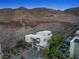 Aerial view of a modern home next to a community pool with mountain views and drought-tolerant landscaping at 865 Auroras Edge Ct, Henderson, NV 89012