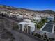 Aerial view of a modern home nestled in a desert community with mountain views and manicured landscaping at 865 Auroras Edge Ct, Henderson, NV 89012