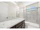 Bright bathroom featuring a granite countertop, dark wood cabinets, and glass-enclosed shower at 865 Auroras Edge Ct, Henderson, NV 89012