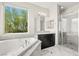 Bright bathroom featuring a soaking tub, granite counters, and glass shower with a built in seat at 865 Auroras Edge Ct, Henderson, NV 89012