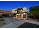 Contemporary home with a paved driveway, desert landscaping, and a mountain backdrop at 865 Auroras Edge Ct, Henderson, NV 89012
