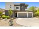 Modern two-story home with a three-car garage and beautiful desert landscaping at 865 Auroras Edge Ct, Henderson, NV 89012