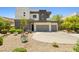Contemporary home showcasing modern architecture, desert landscaping, and a three-car garage at 865 Auroras Edge Ct, Henderson, NV 89012