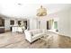 Bright living space featuring wood-look floors, stylish lighting, and an open layout to the kitchen and outdoor area at 865 Auroras Edge Ct, Henderson, NV 89012