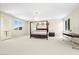 A spacious main bedroom with desert mountain views from windows, features a four-poster bed at 865 Auroras Edge Ct, Henderson, NV 89012