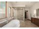 Elegant bathroom featuring a soaking tub, a glass-enclosed shower, and modern fixtures at 8725 Newport Isle Ct, Las Vegas, NV 89117