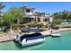 Luxury waterfront home with private dock and boat on a sunny day, showcasing waterfront living at 8725 Newport Isle Ct, Las Vegas, NV 89117