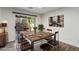 Inviting dining room with sliding glass door, wood table set, and unique wall art at 9006 Cedar Door Ave, Las Vegas, NV 89148